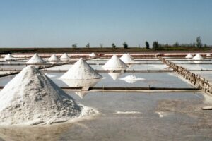 Scenic view of traditional salt fields with salt mounds under a clear sky in Tainan, Taiwan.