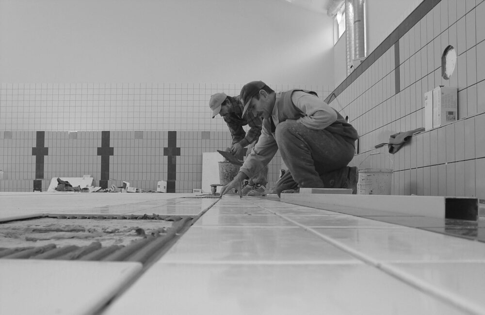 Professional workers tiling a bathroom interior, showcasing expertise in construction.