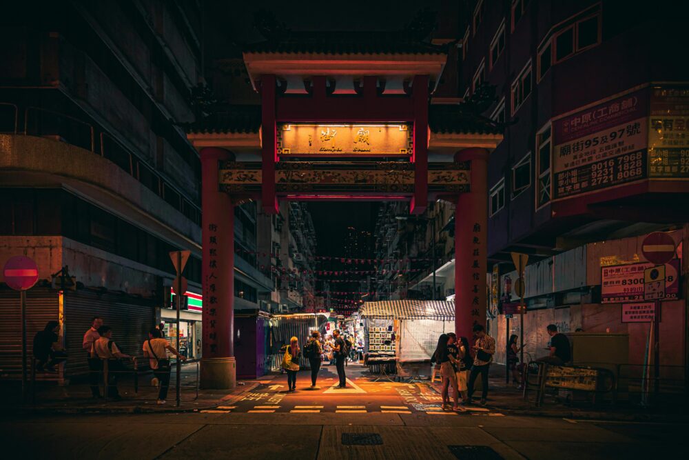 A lively scene at a bustling night market with colorful lights and people