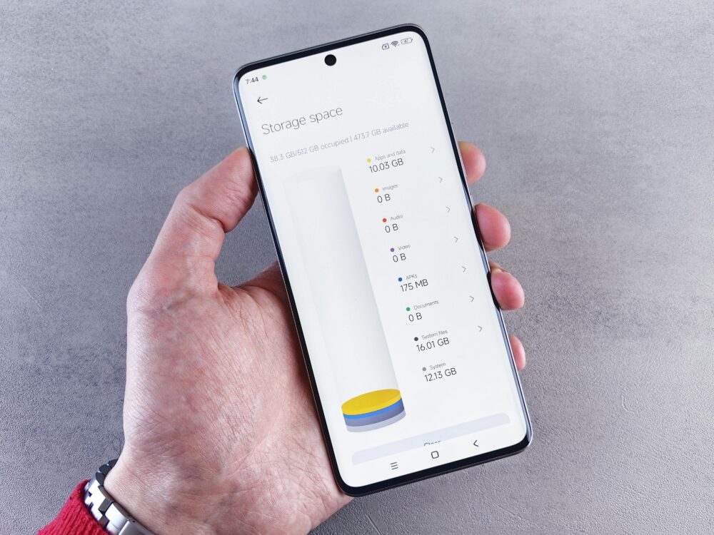 Hand holding smartphone displaying storage space usage with a clean interface.