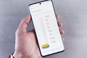 Hand holding smartphone displaying storage space usage with a clean interface.