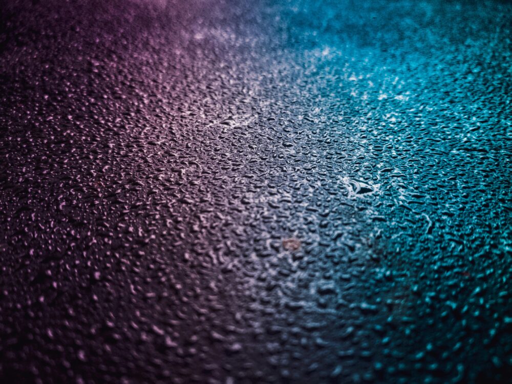 Close-up of vibrant water droplets on a textured surface