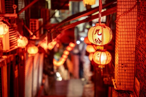 Vibrant night scene of a narrow street in Taipei adorned with glowing red lanterns, creating a warm atmosphere.