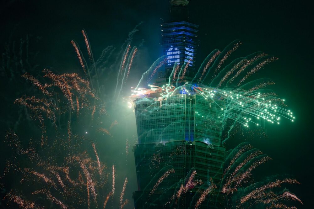 New Year fireworks display illuminating Taipei 101 in Taiwan at night.