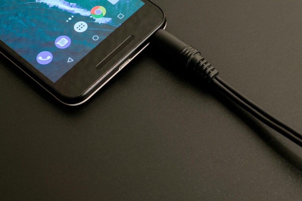 Close-up of a smartphone being charged, displaying a modern interface on a dark backdrop.