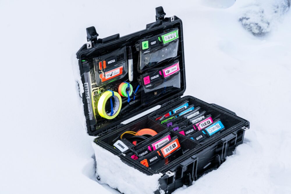 Professional camera gear neatly organized in a snow-covered case