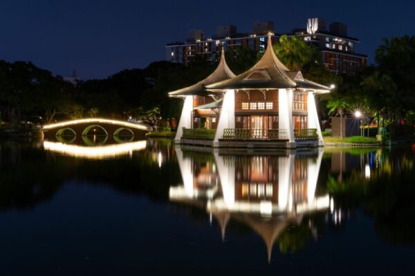 Illuminated traditional pavilion reflecting on a serene lake in Taichung City, Taiwan
