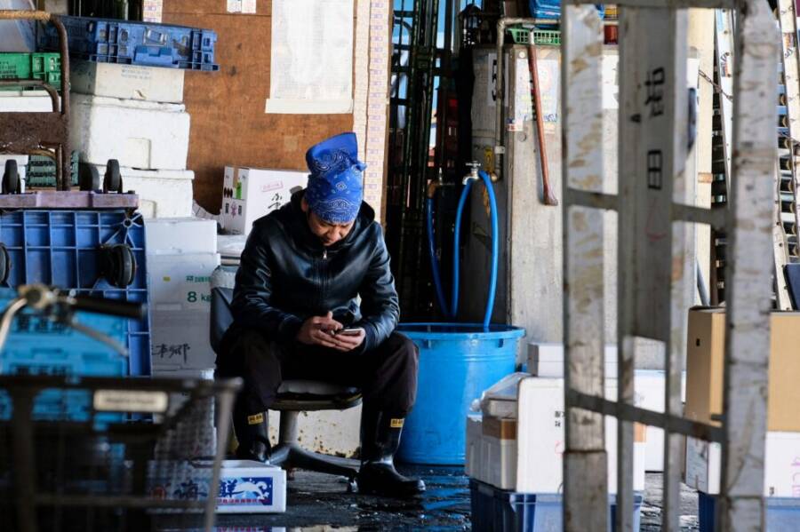 Warehouse worker with a rugged phone on the floor