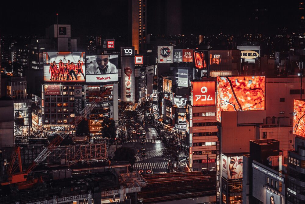 Vibrant night scene of Shibuya, Tokyo with illuminated billboards and busy streets.