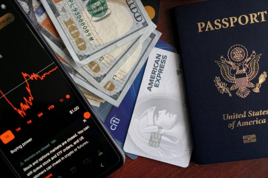 Stock trading concepts with passport, credit cards, cash, and smartphone app image