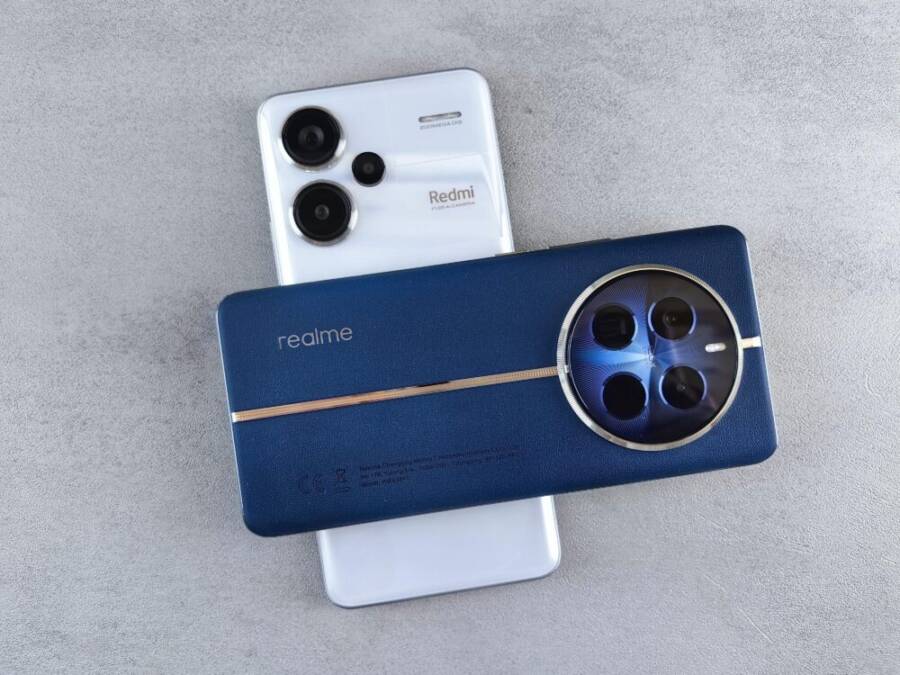 Close-up view of Realme and Redmi smartphones placed on a grey textured surface, showcasing modern technology design.