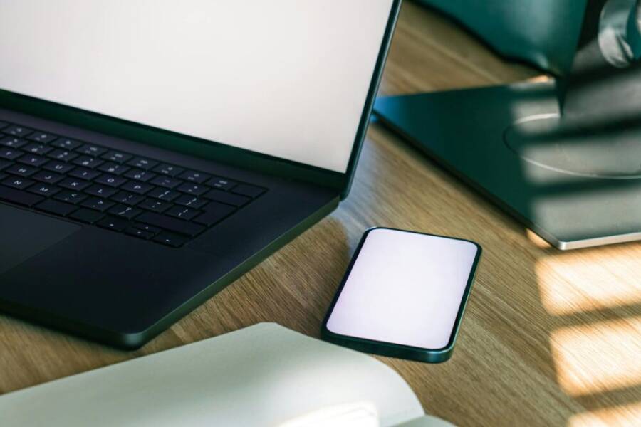 A sleek office desk setup featuring a laptop and smartphone, ideal for tech and business themes