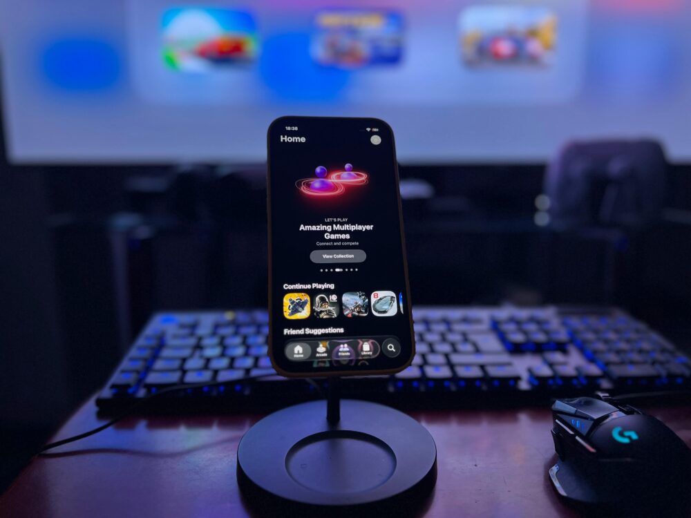 A stylish gaming setup featuring a smartphone on a stand with a vibrant display, keyboard, and mouse.