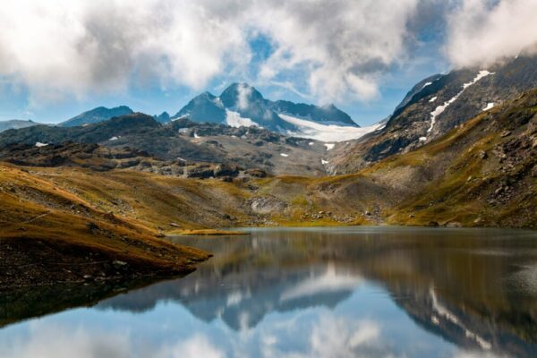 Stunning alpine scenery with mountains and a lake reflecting the serene sky