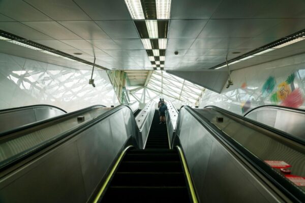 View of an escalator in a modern Taipei metro station with unique architecture.