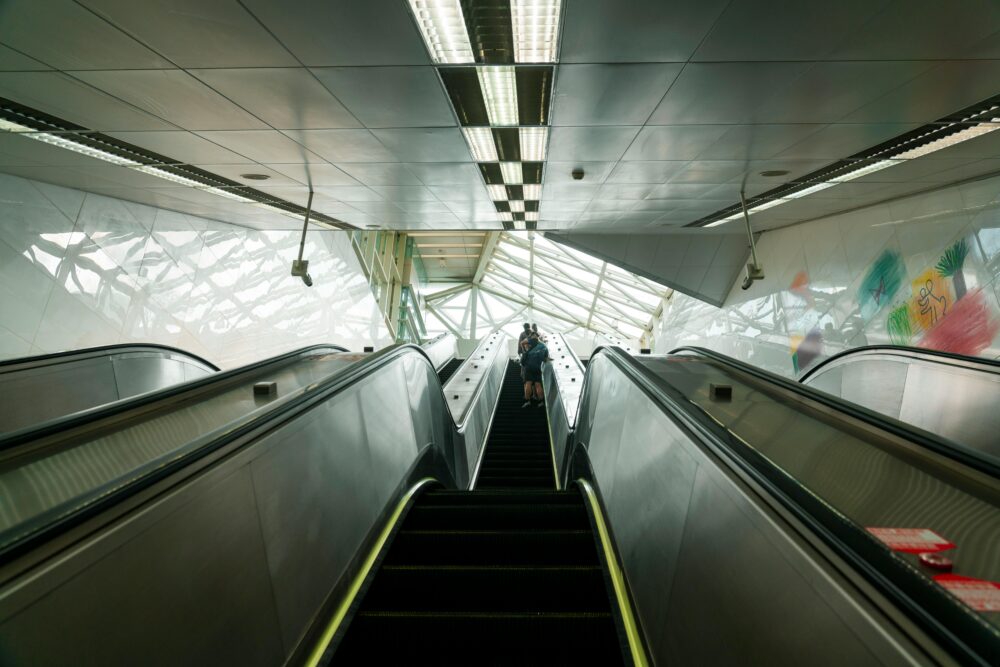 View of an escalator in a modern Taipei metro station with unique architecture.