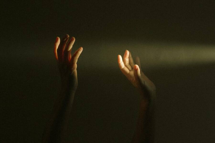 Expressive hands reaching towards a ray of light symbolize hope and mental resilience