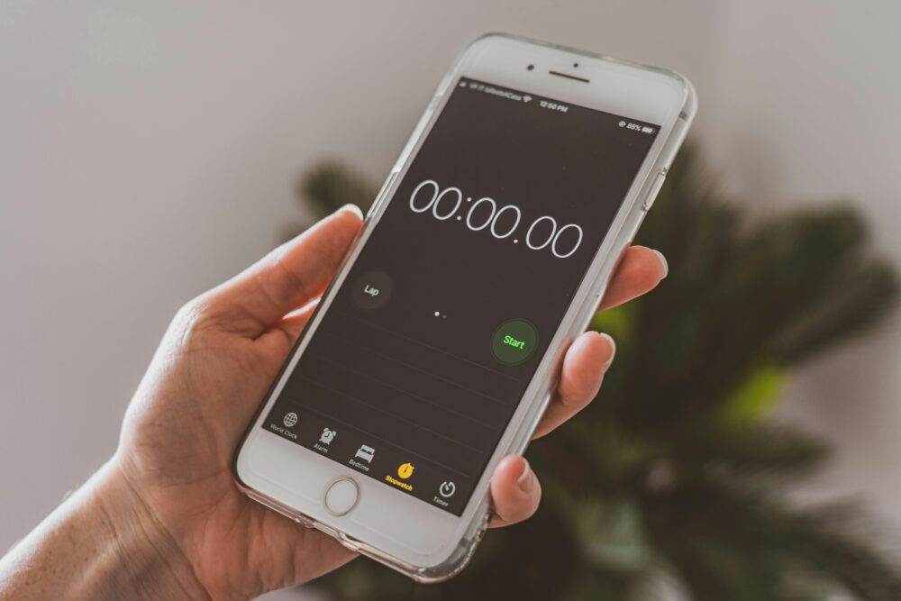 Smartphone held in hand displaying a stopwatch timer app