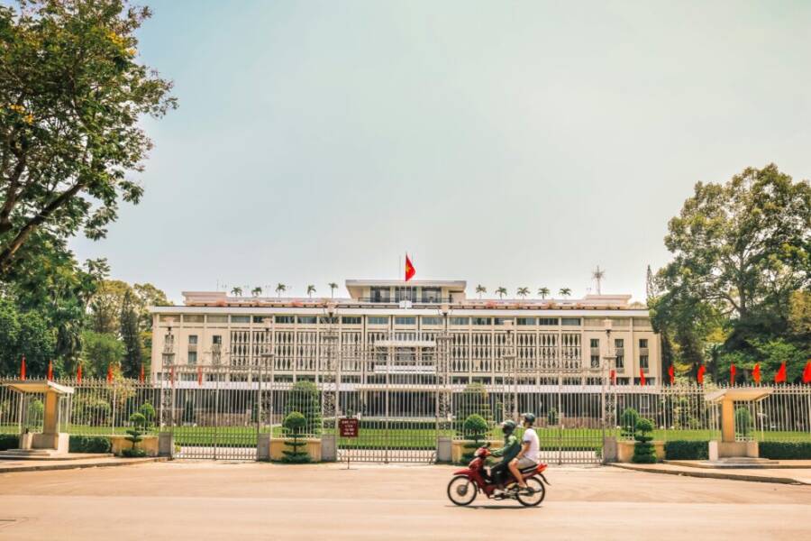 Vibrant view of Independence Palace with motorcyclists in Saigon, Vietnam