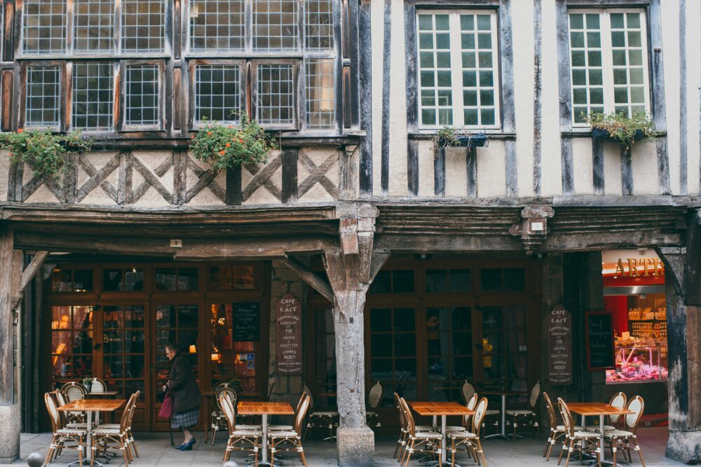 Historic European cafe with timber facade and outdoor seating in a quaint town setting