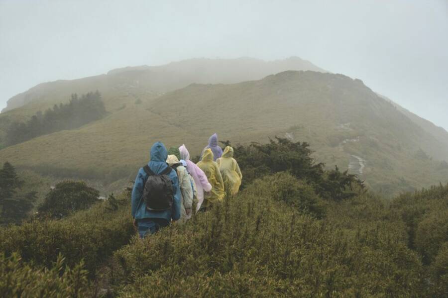 A group of hikers in colorful raincoats trekking through Taiwan
