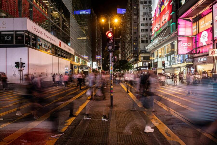 Long exposure of bustling night life in central Hong Kong, capturing urban energy and dynamic city movement