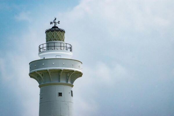 Low angle view of Eluanbi Lighthouse with wind instrument under a clear blue sky.