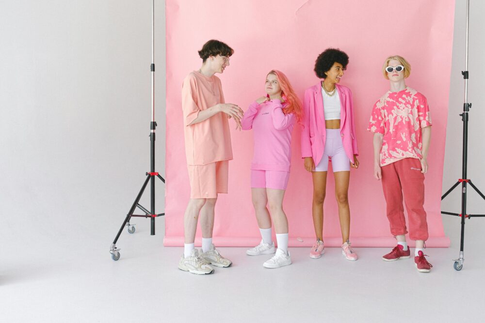 Full body of diverse teenage friends talking and smiling in professional photo studio with special equipment
