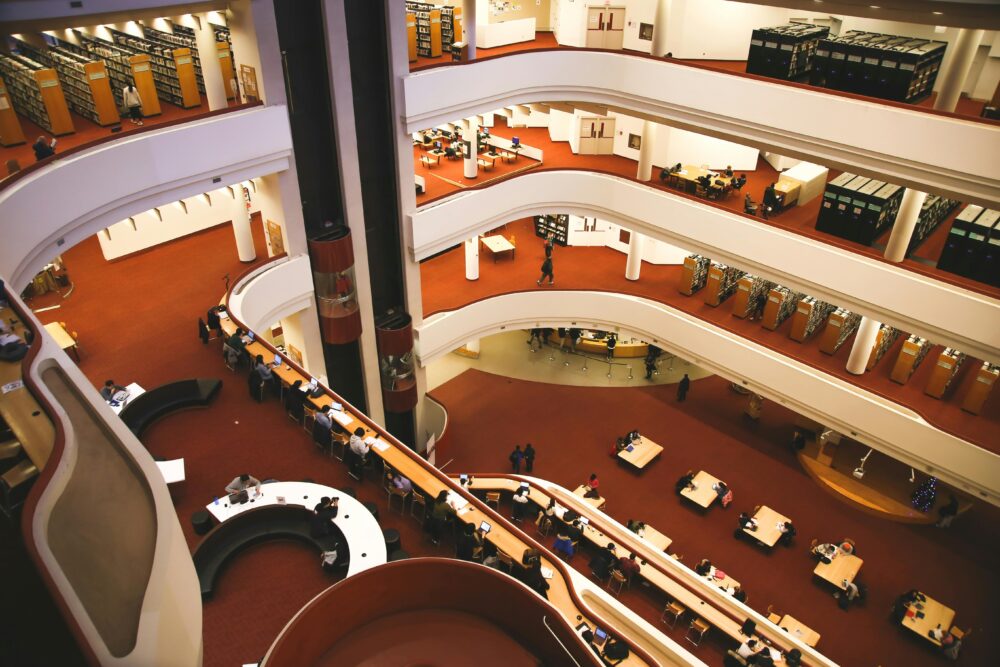 Aerial view of a multistory library interior with people studying at tables in Toronto.
