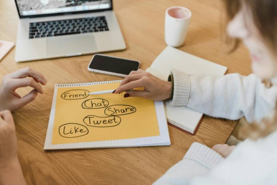 image of two people planning social media strategy with a phone and notebook
