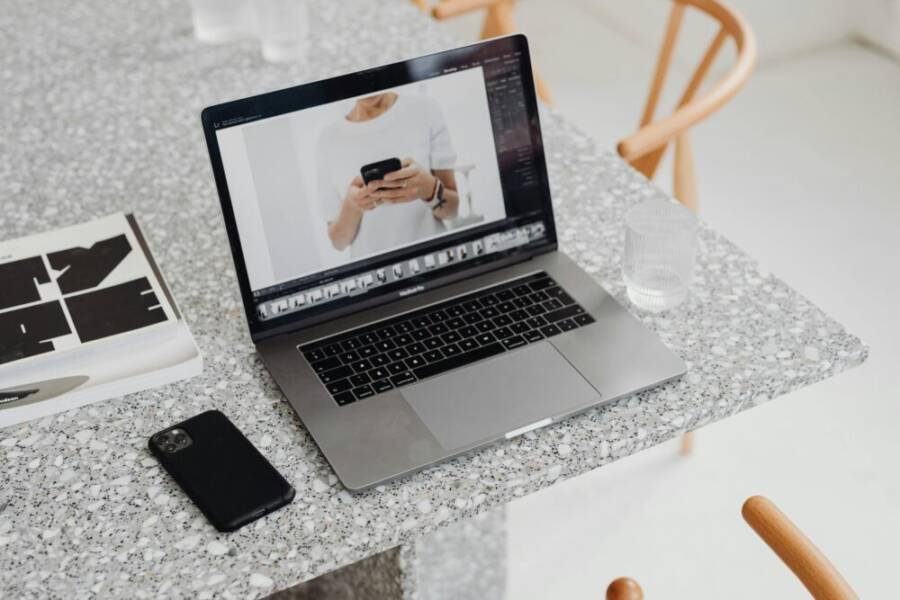 High angle view of a sleek laptop and smartphone on a marble table, perfect for creative and tech work settings.