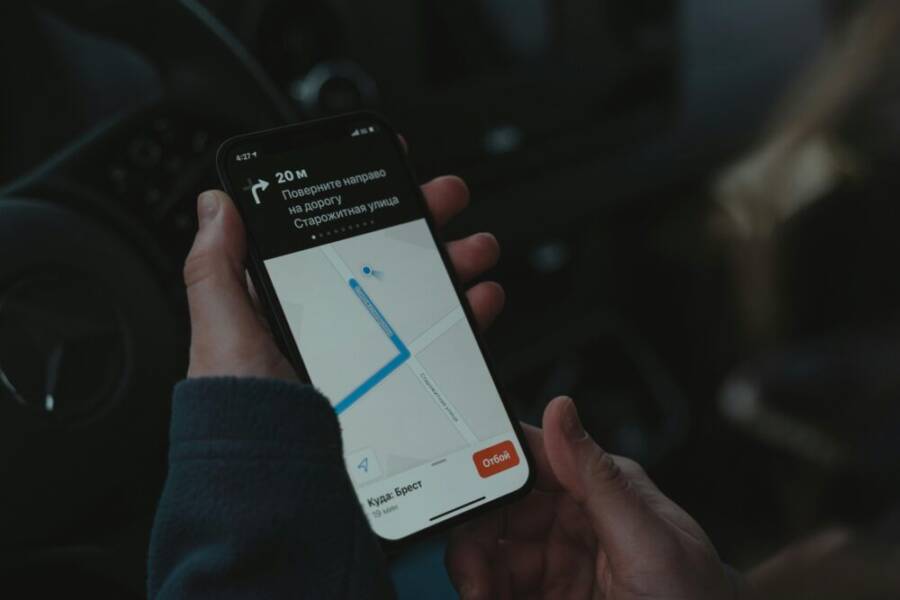 Close-up of a smartphone displaying a navigation app in a car