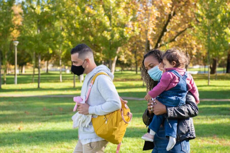 A family enjoying a walk in the park during autumn