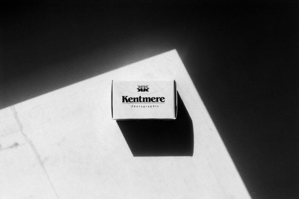 Black and white top view of package of professional film with inscription placed on surface with bright sunlight and shadow