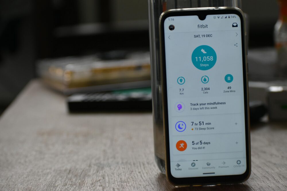 Close-up of a smartphone displaying a fitness tracking app with health statistics