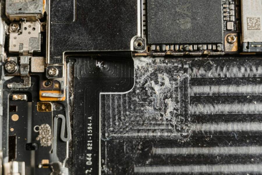 Detailed close-up of a dusty mobile phone circuit board showcasing various electronic components.