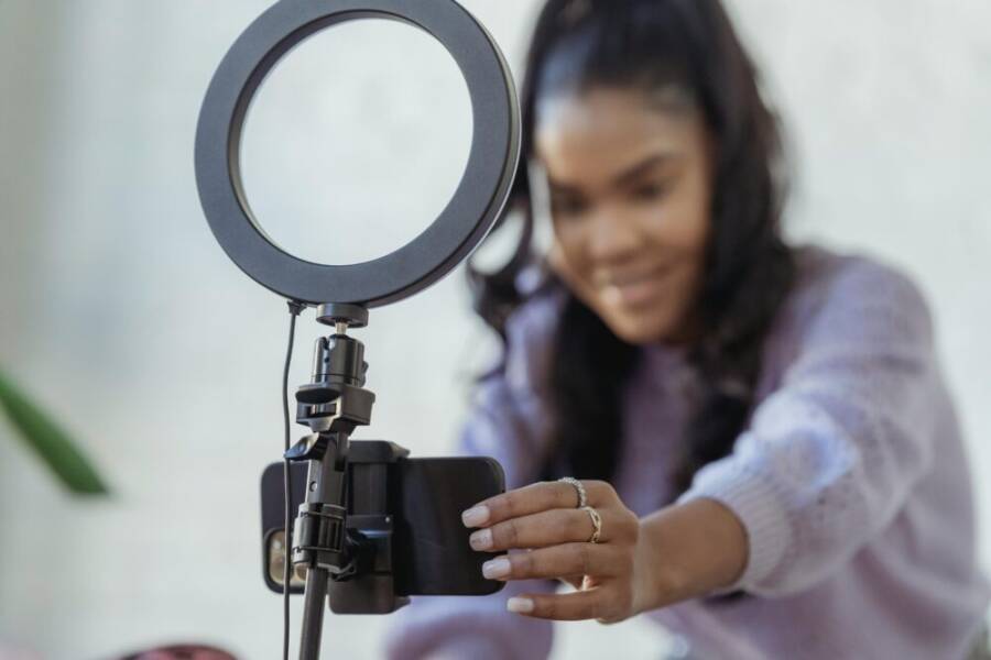 Cheerful blogger setting up camera on a smartphone
