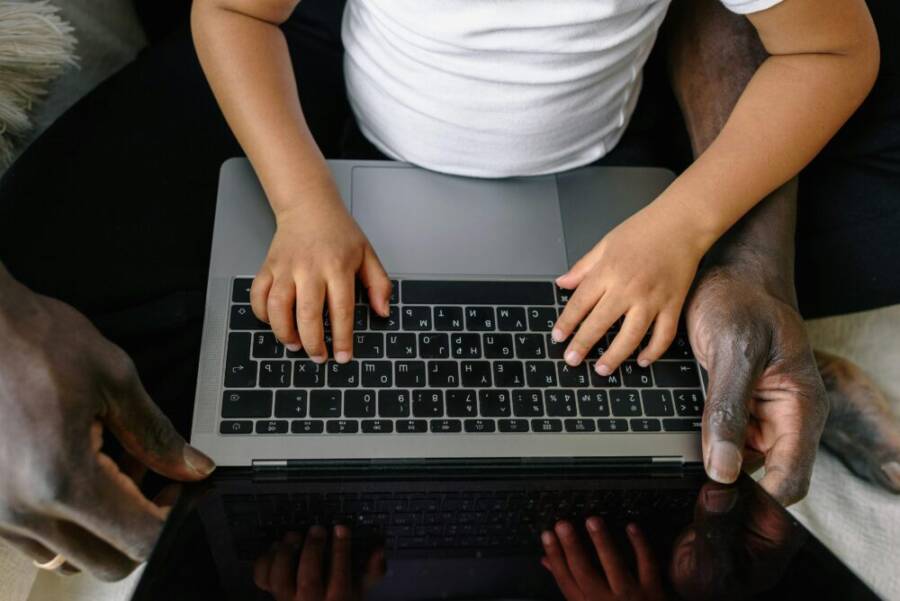 A child and adult learning together with a laptop