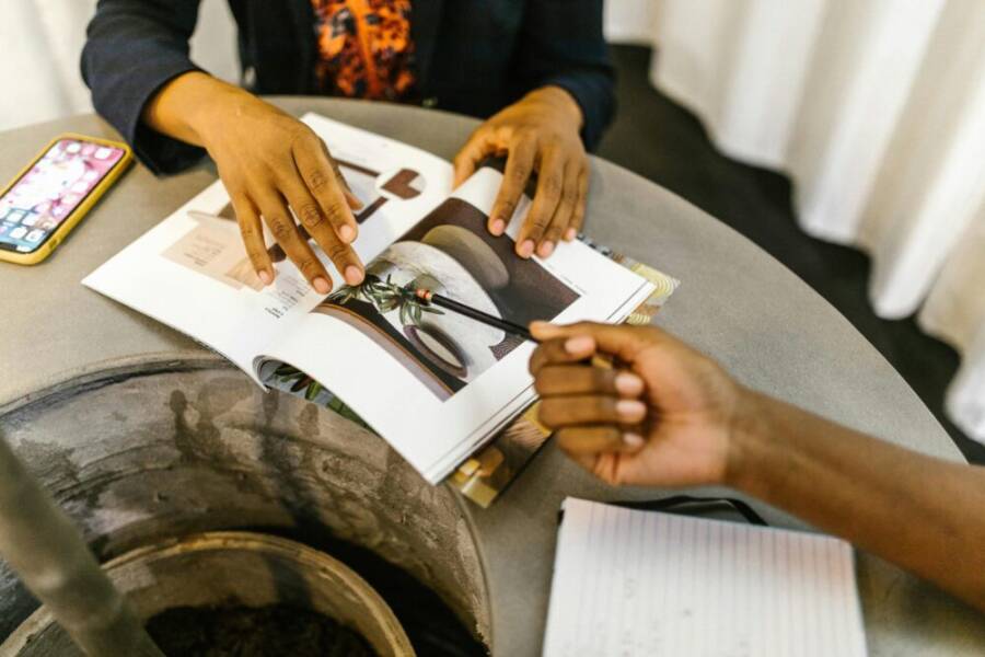 Colleagues discuss ideas over a modern magazine with notes and smartphone on table