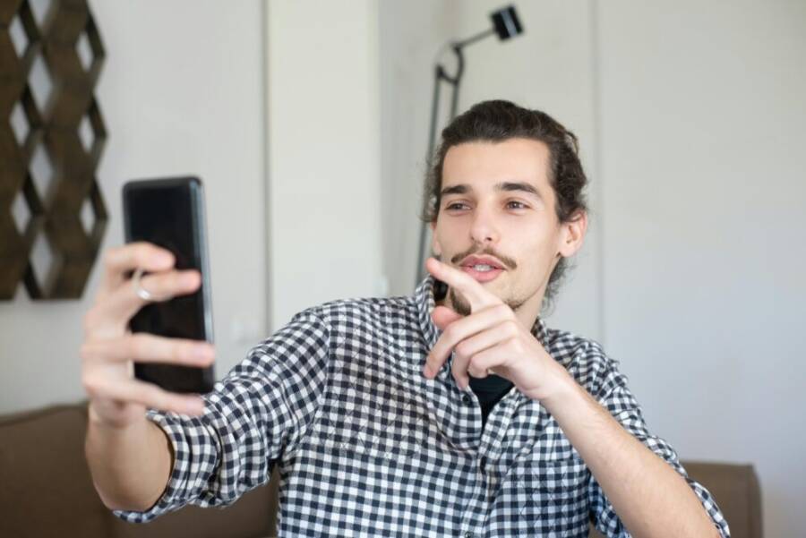 Young man filming with smartphone