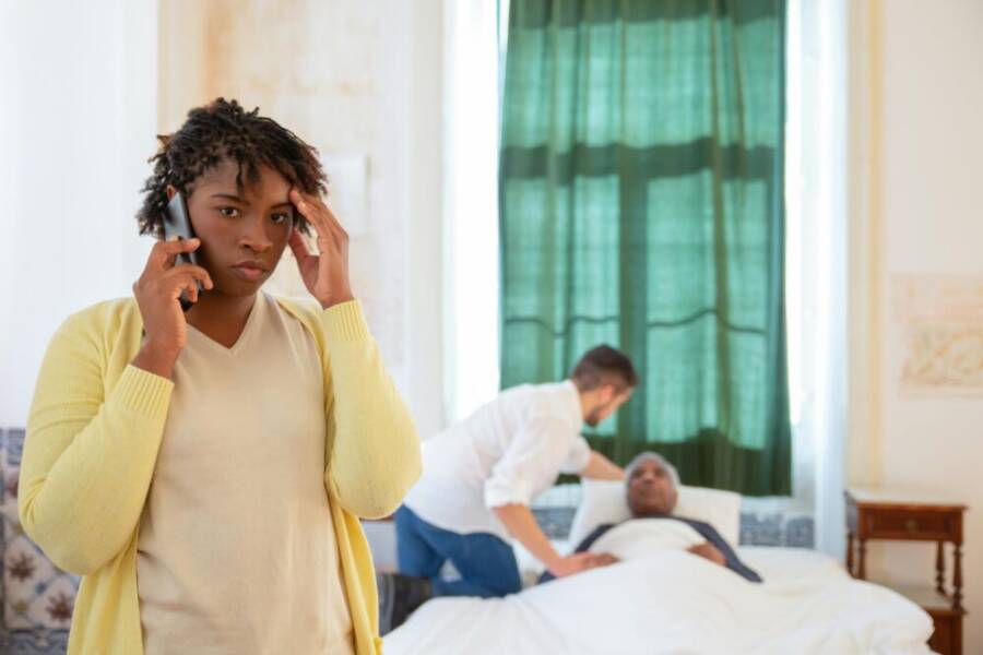 A senior using a phone with a caregiver nearby, illustrating emergency support