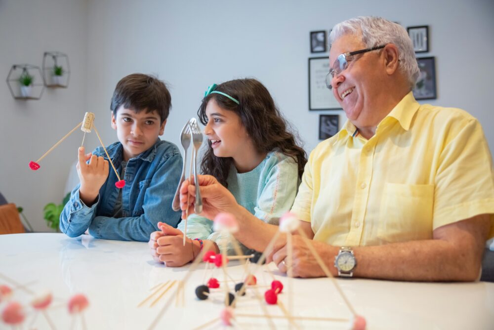 Grandfather enjoying a creative and fun afternoon with grandchildren using building sticks.