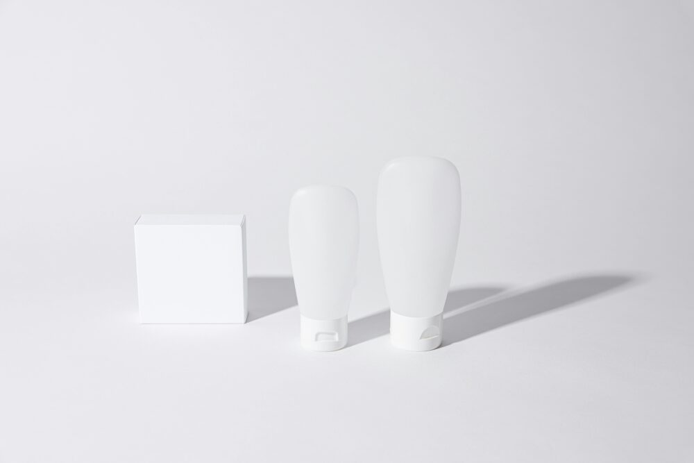 Minimalist white cosmetic containers with shadows, perfect for product mockups and ad designs