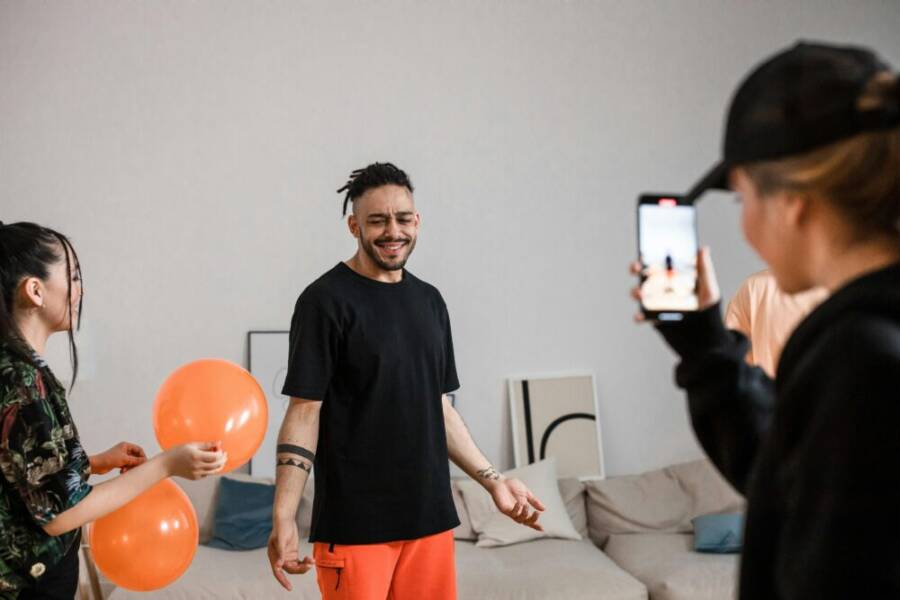 A group of friends filming a playful TikTok dance video indoors