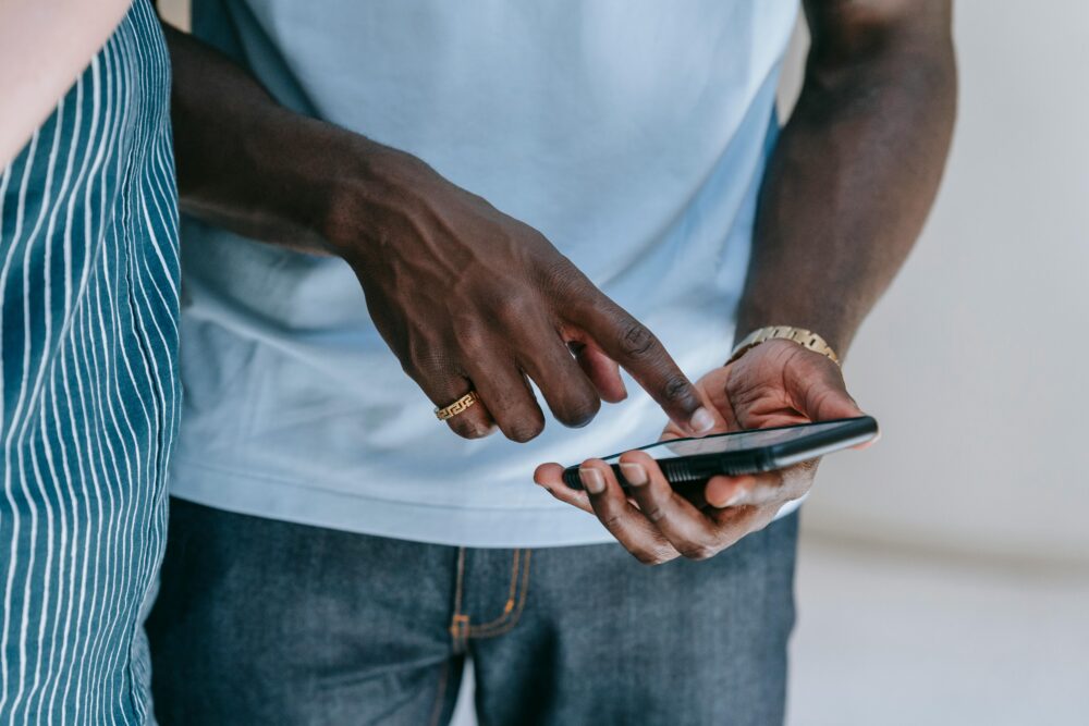 Close-up of a person interacting with a smartphone, captured indoors in a casual setting.
