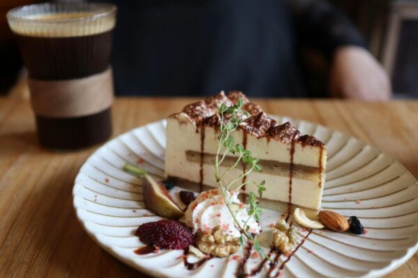 Close-up of tiramisu with nuts and coffee on a wooden table, creating a delicious culinary setting