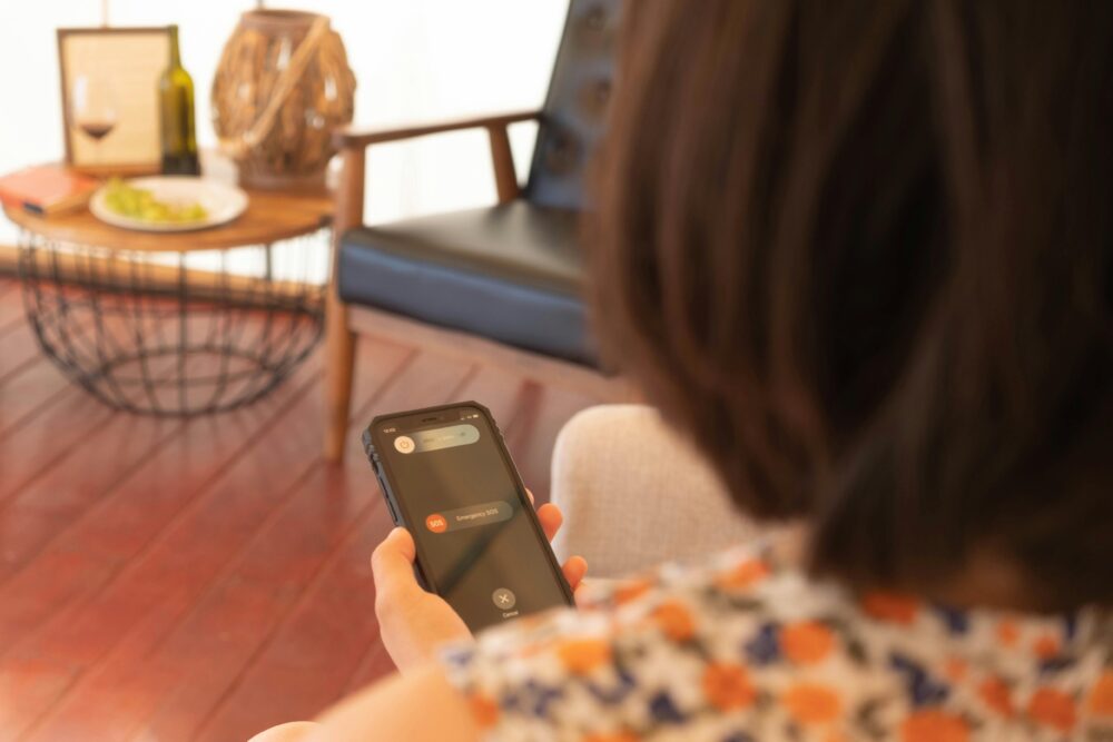 A person setting up emergency contacts on a smartphone indoors