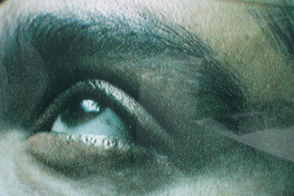 Detailed view of a human eye seen through screen texture, creating a unique visual effect.