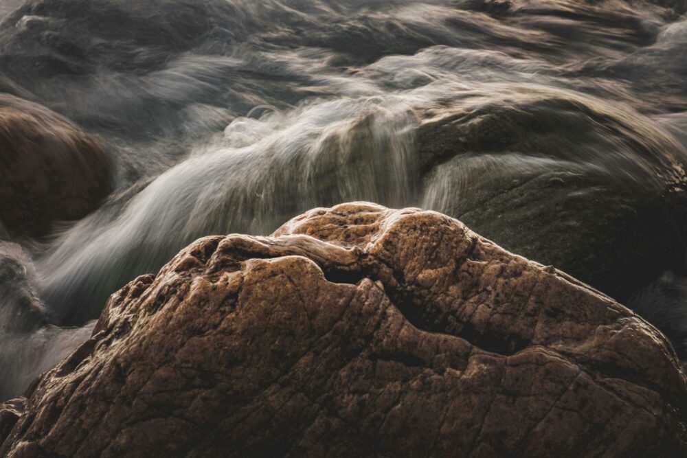 Long exposure of water cascading over rugged boulders, capturing nature