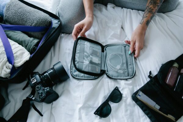 Travel essentials laid out for a trip on a bed